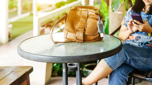 Midsection of woman using mobile phone while sitting on chair