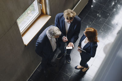 Business people with smartphone talking in modern office building