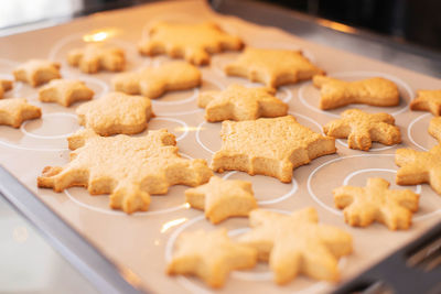 Baking tray with ginger christmas cookies snowflakes in the oven. christmas kitchen interior.
