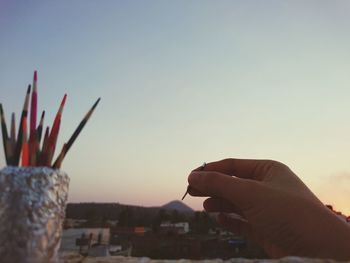 Close-up of hand painting against clear sky