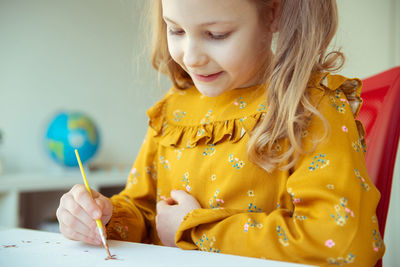 Cute girl painting while sitting at home