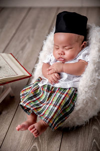 Portrait of cute girl sitting on bed at home