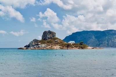 Rock formations by sea against sky