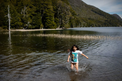 Rear view of girl playing in lake