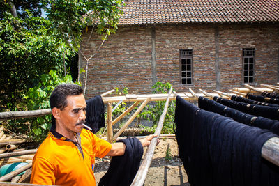  the craftsmen do the dyeing process of the fabric lurik in tringsing village,  java, indonesia