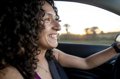 Close-up of young woman holding steering wheel