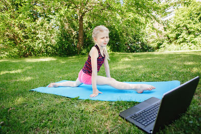 Full length of girl exercising at park