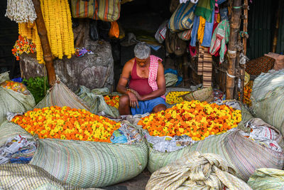 High angle view of woman sitting at market stall