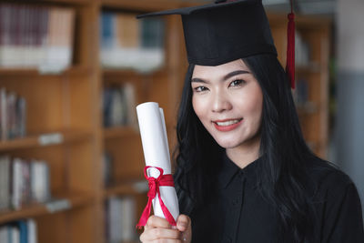 Portrait of smiling young woman holding camera