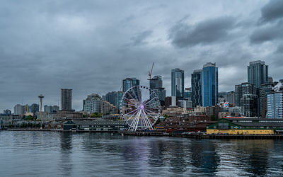 Modern buildings in city against cloudy sky