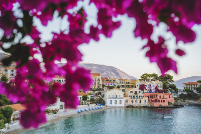 Buildings by river against sky in city