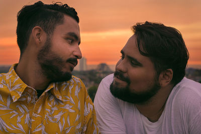 Portrait of young man looking at young man at sunset 