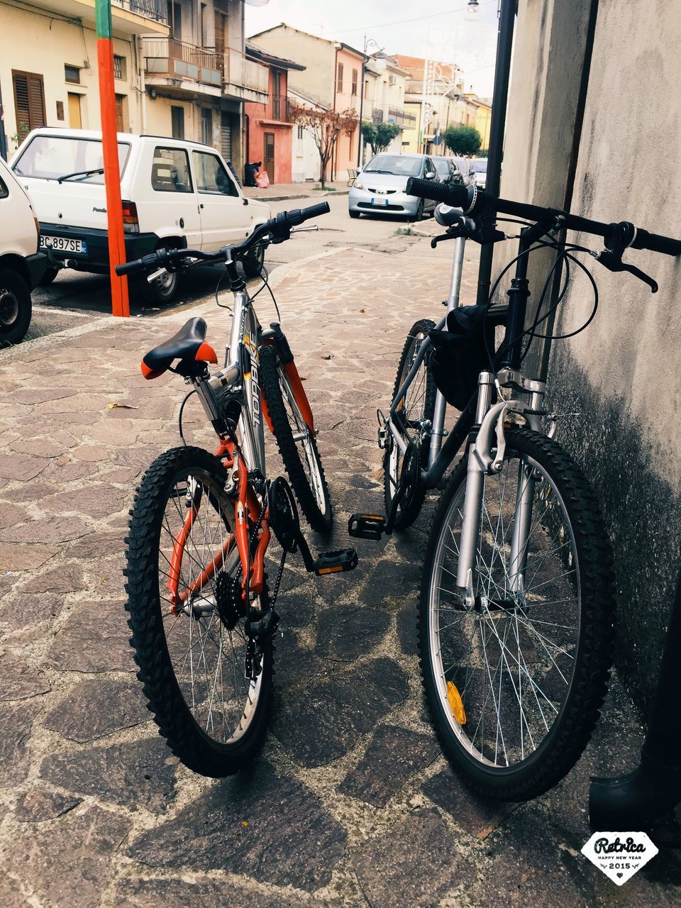 bicycle, transportation, mode of transport, land vehicle, stationary, parked, parking, street, road, building exterior, architecture, cycle, built structure, car, travel, riding, day, outdoors, parking lot, motorcycle