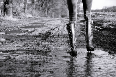 Low section of woman walking on dirt road