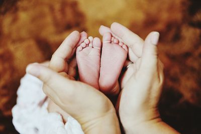 Cropped hand of mother cupping baby feet