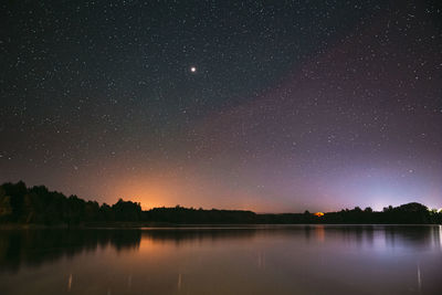 Scenic view of lake against sky at night