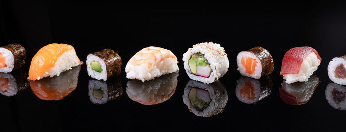 Close-up of sushi against black background