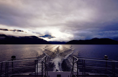 Silhouette of mountain and sea against sky