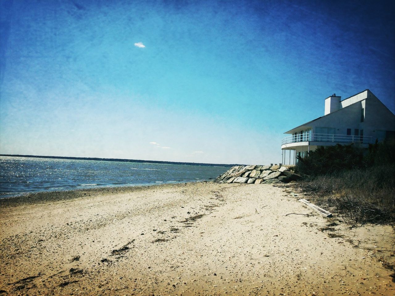 beach, sea, sand, horizon over water, water, shore, built structure, blue, architecture, building exterior, sky, tranquil scene, tranquility, scenics, clear sky, coastline, nature, beauty in nature, copy space, sunlight