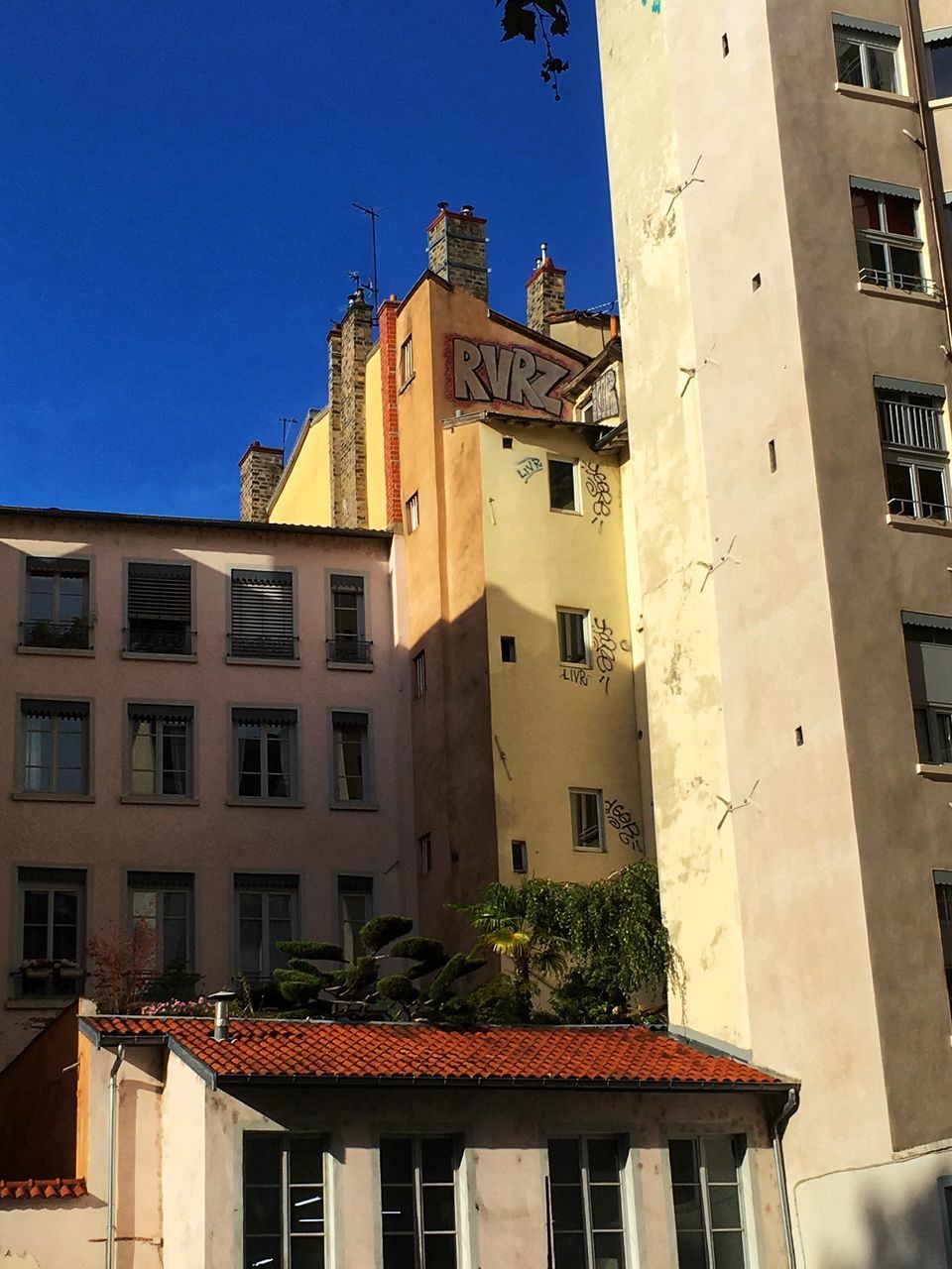 LOW ANGLE VIEW OF BUILDINGS AGAINST CLEAR BLUE SKY