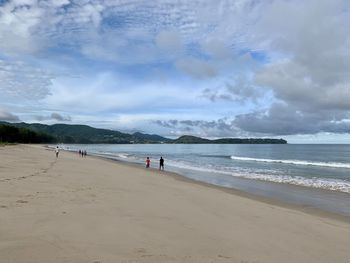 People on beach against sky