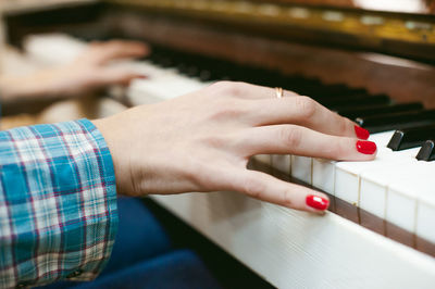 Close-up of hand playing piano