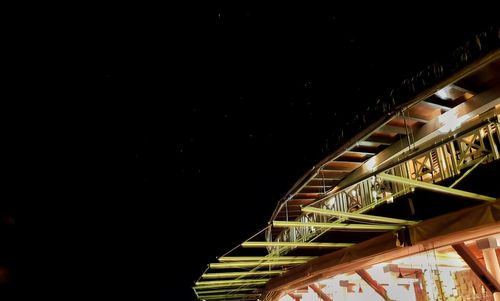 Low angle view of illuminated bridge against sky at night