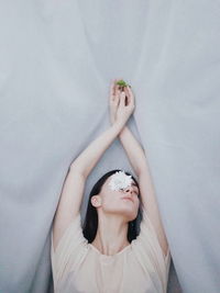 High angle view of woman with flower lying on textile