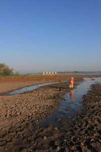 Man on beach against clear sky