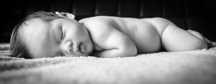 Close-up of baby lying on bed