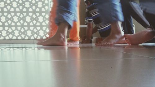 Low section of woman standing on tiled floor