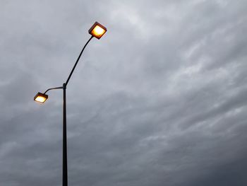 Low angle view of illuminated street light against sky