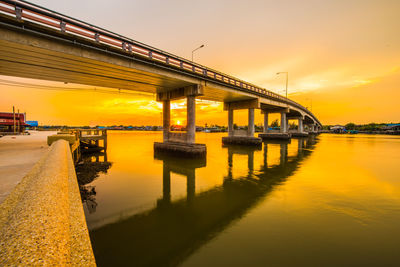 Bridge over river against sky during sunset