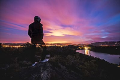 Digital composite of man standing on land against sky during sunset