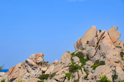 Low angle view of rocks against blue sky