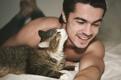 Midsection of man with cat at home