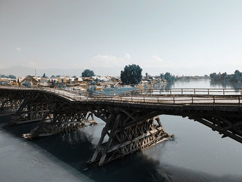 Bridge over river against sky in city