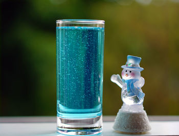 Close-up of snow globe by drink on table