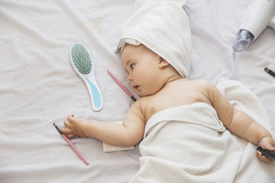 High angle view of cute baby girl lying on bed at home