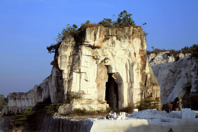 Low angle view of rock formation against clear blue sky