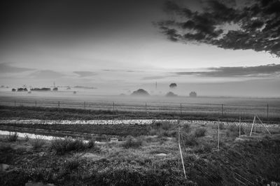 Scenic view of field against cloudy sky