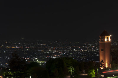 Illuminated cityscape against clear sky at night