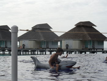Woman relaxing on beach against sky