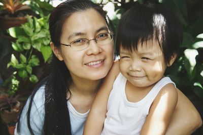 Portrait of smiling mother embracing cute son