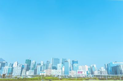 Skyscrapers in city against clear blue sky