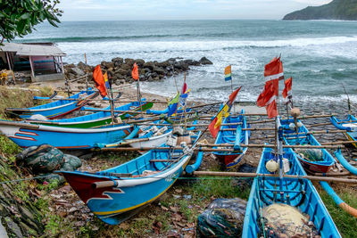 Boats moored by sea against sky