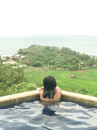 Rear view of woman looking at swimming pool