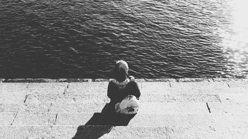 Rear view of woman sitting on beach