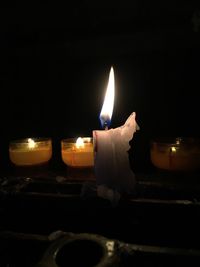 Close-up of burning candle in darkroom