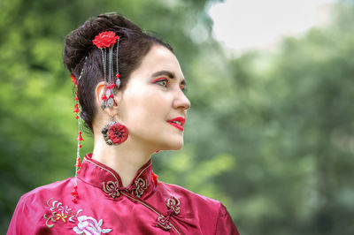 Portrait of young woman looking away outdoors